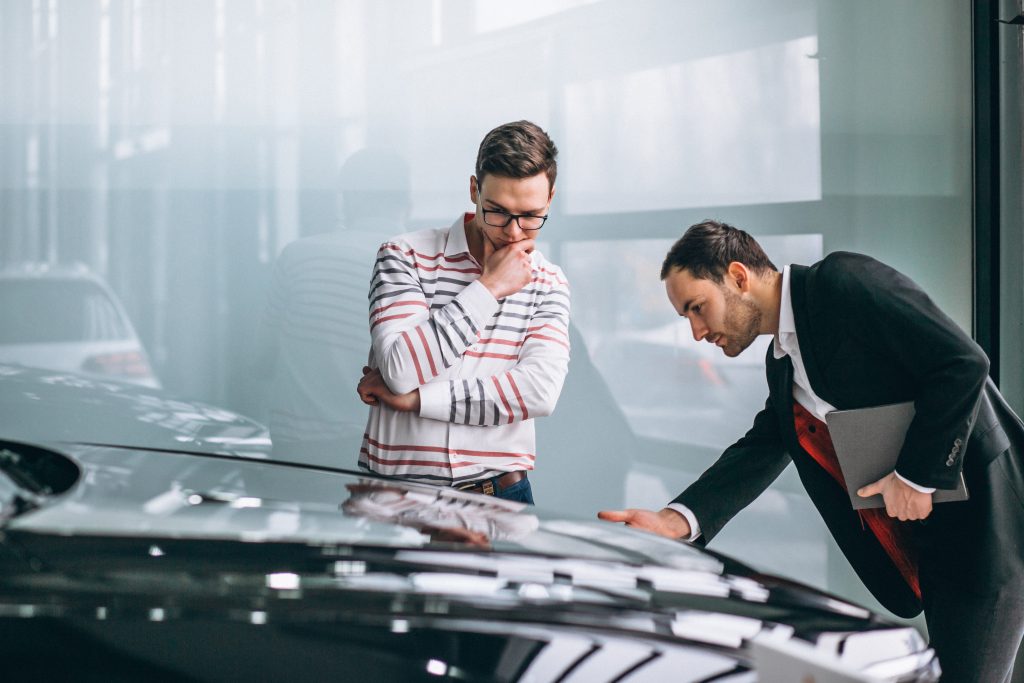 Salesman At A Car rental showroom with renter